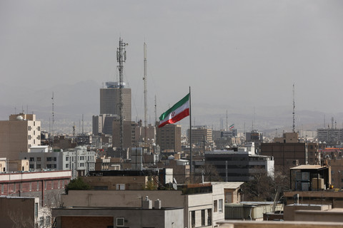 Bendera Iran berkibar setelah Israel dan AS melancarkan serangan terhadap Iran, di Teheran, Iran, Sabtu (28/2/2026). Foto: Majid Asgaripour/WANA via Reuters
