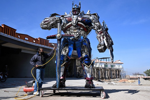 Seniman asal Pakistan Ehtisham Jadoon mengubah limbah logam dan suku cadang bekas menjadi patung raksasa karakter Optimus Prime. Foto: Farooq Naeem/AFP