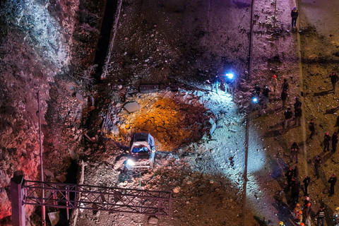 Pemandangan dari drone yang memperlihatkan petugas tanggap darurat Israel bekerja di lokasi serangan rudal Iran di jalan raya, setelah Iran melancarkan rentetan rudal menyusul serangan AS dan Israel, di Yerusalem, 1 Maret 2026.  Foto: REUTERS/Ilan Rosenberg