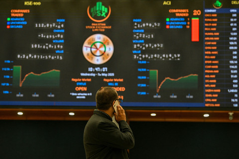 Seorang pialang saham memantau harga saham di layar digital di Bursa Saham Pakistan (PSX) di Karachi pada 7 Mei 2025. Foto: Asif Hassan/AFP