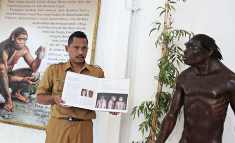 Edukator Museum Situs Purbakala Patiayam, Ari Mustaqim menunjukkan koleksi foto manusia purba. Foto: Vega Maarijil Ula/kumparan