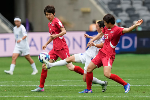 Diyorakhon Khabibullaeva dari Uzbekistan, di tengah, berebut bola dengan Ri Hye Gyong dari Korea Utara, di sebelah kanan, dan Myong Yu Jong selama pertandingan sepak bola Piala Asia Wanita antara Korea Utara dan Uzbekistan di Sydney, Selasa, (3/3). Foto: AP Photo/Rick Rycroft