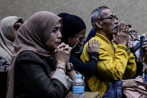 Kerabat terdakwa kasus dugaan suap terhadap putusan lepas perkara korupsi pemberian fasilitas ekspor minyak sawit mentah (CPO) Junaedi Saibih berdoa saat menghadiri sidang vonis di Pengadilan Tipikor, Jakarta, Selasa (3/3/2026). Foto: Darryl Ramadhan/ANTARA FOTO