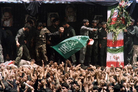 Pasdaran berusaha menenangkan kerumunan yang histeris di depan panggung tempat Ayatollah Ruhollah Khomeini disemayamkan di pemakaman Behesht Zahra di Teheran pada 6 Juni 1989. Foto: CHRISTOPHE SIMON; PASCAL GEORGE/AFP