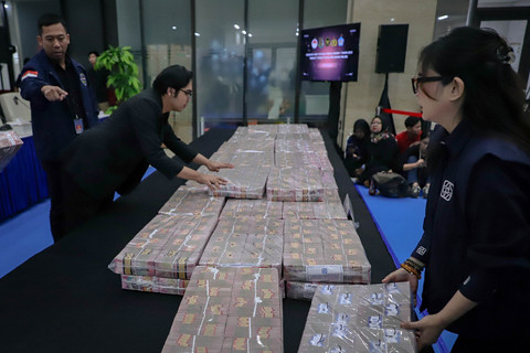 Petugas menata uang sejumlah Rp 58 miliar untuk ditunjukkan saat konferensi pers terkait penyerahan tanggung jawab dan eksekusi harta kekayaan hasil TPPU yang berasal dari praktik judi online di Bareskrim Polri, Jakarta, Kamis (5/2/2026). Foto: Jamal Ramadhan/kumparan