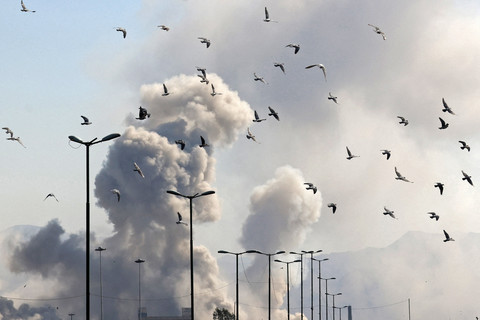 Burung-burung terbang di tengah kepulan asap setelah serangan di ibu kota Iran, Teheran, Kamis (5/3/2026). Foto: Atta Kenare/AFP