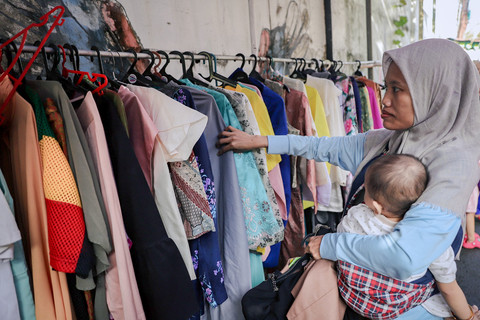 Warga mengambil bahan makanan gratis dan pakaian layak pakai saat kegiatan Bazaar Ramadan di permukiman RT 02/RW 04, Jati Padang, Jakarta, Sabtu (7/3/2026). Foto: Jamal Ramadhan/kumparan