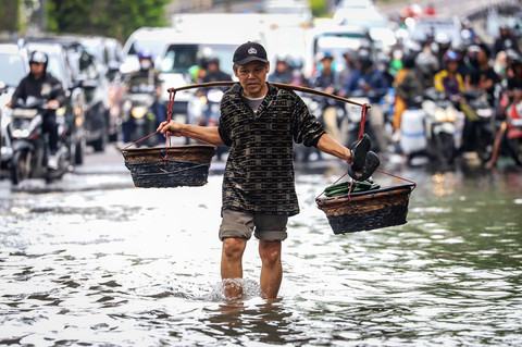 Warga berjalan melintasi banjir yang merendam ruas Jalan Kapten Pierre Tendean usai hujan deras terjadi di kawasan Mampang, Jakarta Selatan, pada Minggu (8/3/2026). Foto: Iqbal Firdaus/kumparan
