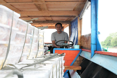 Menu makanan MBG berada dalam perahu yang akan berangkat menyusuri arus Sungai Musi di Wilayah Gandus, Palembang. Foto: Dok. Bakom RI