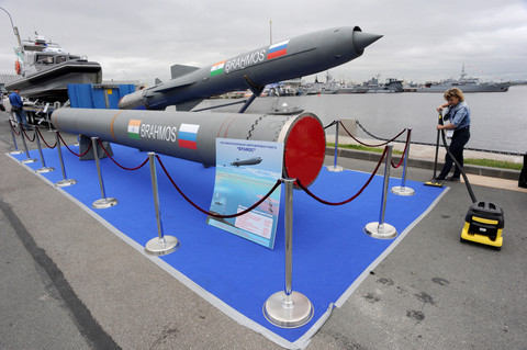 Seorang wanita membersihkan karpet di dekat rudal jelajah supersonik Brahmos di Pameran Pertahanan Maritim Internasional di St. Petersburg pada 2 Juli 2015. Foto: Olga Maltseva / AFP