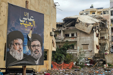 Sebuah foto menunjukkan spanduk para pemimpin Hizbullah, yang tewas, Hassan Nasrallah (kiri) dan Hashem Safieddine, di lokasi serangan udara Israel semalam yang menargetkan lingkungan Burj al-Barajneh di pinggiran selatan Beirut, Sabtu (14/3/2026). Foto: AFP