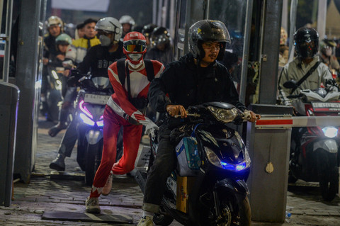Seorang pemudik berkostum pahlawan super, Aji Pangestu (kiri) mendorong motornya memasuki antrean di Pelabuhan Ciwandan, Kota Cilegon, Banten, Kamis (19/3/2026) dini hari. Foto: Muhammad Bagus Khoirunas/ANTARA FOTO