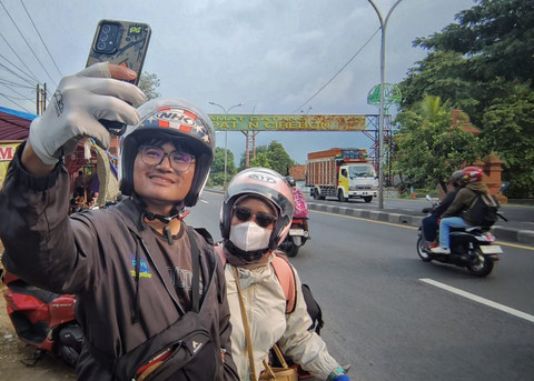 Lukman dan istrinya yang merupakan pasangan pengantin baru dengan tujuan Brebes saat selfie di Gapura Selamat Datang di Kabupaten Cirebon. (19/3/2026). Foto: Panji Asmara/kumparan