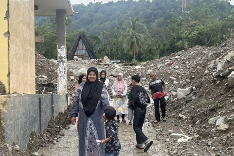 Sejumlah warga berjalan kaki melintasi jalan dengan tumpukan batuan dan material sisa banjir bandang untuk mengunjungi keluarga di Nagari Maninjau, Kabupaten Agam, Sumatera Barat, Sabtu (21/3/2026). Foto: Kuntum Khaira Riswan/ANTARA