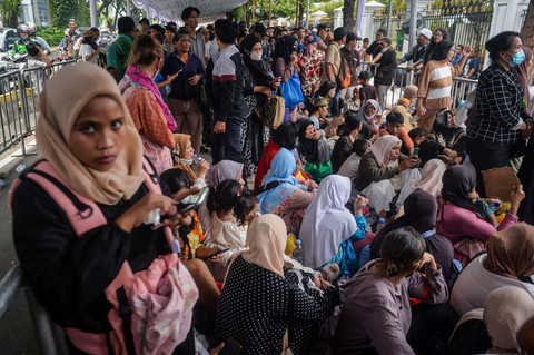Warga duduk saat menunggu antrean halalbihalal dengan Presiden Prabowo Subianto di pintu masuk Kementerian Sekretariat Negara, Jakarta, Sabtu (21/3/2026).  Foto: Putra M. Akbar/ANTARA FOTO 
