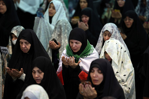 Jemaah Syiah Iran mengikuti salat Idulfitri yang menandai berakhirnya bulan suci Ramadan, di Masjid Agung Mosalla, Teheran (21/3). Foto: STR / AFP