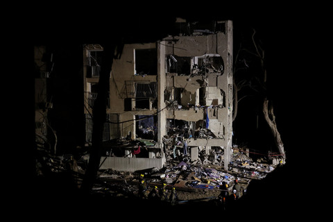 Petugas tanggap darurat memeriksa lokasi serangan rudal Iran di Arad, Israel, Sabtu (21/3/2026). Foto: Ilia YEFIMOVICH / AFP