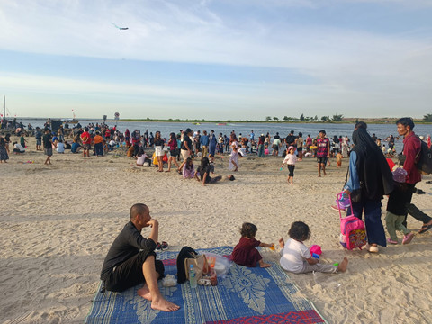 Para anak saat bermain sepak bola dan layangan di area Pantai Ancol, Minggu (22/3).  Foto: Ryan Iqbal/kumparan