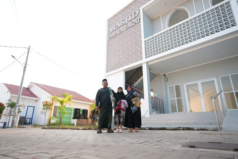 Warsana bersama istri dan anaknya di depan rumah baru mereka di Kampung Nelayan Sejahtera, Desa Eretan Kulon, Kabupaten Indramayu. Usai salat Idulfitri di masjid setempat, Sabtu (21/3/2026) mereka merayakan lebaran pertama dengan rasa tenang.   Foto: Dok. Biro Humas Kemensos / Adhytia D. Lesmana