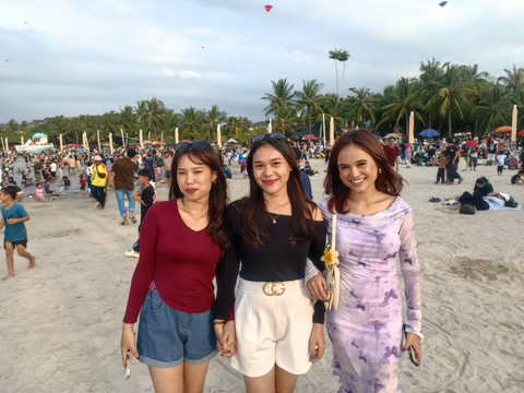 Ina (28) bersama kedua temannya saat menikmati sore di Pantai Ancol, Minggu (22/3). Foto: Ryan Iqbal/kumparan