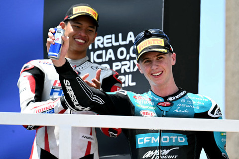 Pebalap Tim CFMOTO Gaviota Aspar Maximiliano Quiles dan pebalap Tim Honda Asia Veda Pratama merayakan kemenangan di podium Grand Prix Moto3 Brasil di sirkuit internasional Ayrton Senna di Goiania, negara bagian Goias, Brasil, Minggu (22/3/2026). Foto: Evaristo SA / AFP