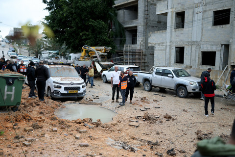 Petugas penyelamat dan aparat keamanan Israel memeriksa lokasi yang terdampak proyektil di Kfar Qassem, Kamis (26/3/2026), setelah serangan rudal yang diluncurkan dari Iran menghantam wilayah tersebut. Foto: ILIA YEFIMOVICH/AFP