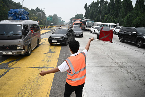 Petugas mengarahkan mobil menuju gerbang keluar tol saat sterilisasi jelang penerapan rekayasa lalu lintas satu arah atau one way di ruas Gerbang Tol Cikampek, Karawang, Jawa Barat, Jumat (27/3/2026). Foto: Fauzan/ANTARA FOTO