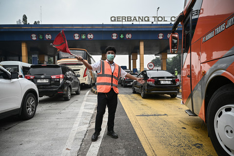 Petugas mengarahkan mobil menuju gerbang keluar tol saat sterilisasi jelang penerapan rekayasa lalu lintas satu arah atau one way di ruas Gerbang Tol Cikampek, Karawang, Jawa Barat, Jumat (27/3/2026).  Foto: Fauzan/ANTARA FOTO