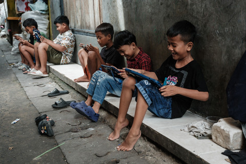 Ilustrasi anak-anak bermain handphone. Foto: Yasuyoshi Chiba/AFP