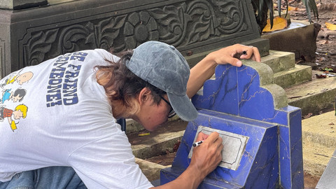 Agus Ponco saat mempertebal tulisan di nisan makam yang sudah luntur. Foto: Pandangan Jogja/Gigih Imanadi Darma