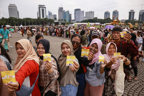 Warga menunjukkan kupon sembako saat antre pada Pasar Murah untuk Rakyat di kawasan Monas, Jakarta, Sabtu (28/3/2026). Foto: Dhemas Reviyanto/ANTARA FOTO