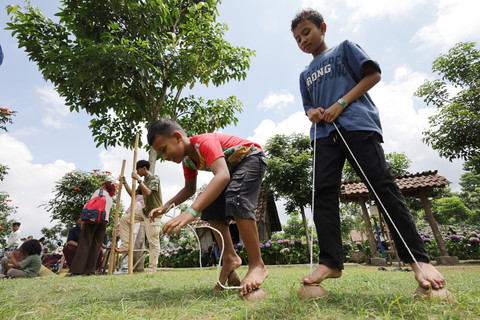 Dua anak bermain egrang batok kelapa di Dusun Kuliner, Kota Batu, Jawa Timur, Minggu (29/3/2026). Foto: Prasetia Fauzani/ANTARA FOTO