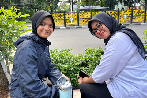 Dari kiri: Elza (18) dan Kamila (18), siswi yang sedang duduk di trotoar dekat zebra cross bergambar di Jalan Dr. Soepomo, Jakarta Selatan, Minggu (29/3/2026). Foto: Ryan Iqbal/kumparan