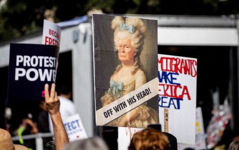 Sebuah poster yang menampilkan Presiden AS Donald Trump berpakaian seperti Marie Antoinette dan kata-kata "Penggal Kepala Mereka" terlihat saat para demonstran berbaris selama hari protes nasional "Tidak Ada Raja" di Los Angeles pada 28 Maret 2026. Foto: ETIENNE LAURENT / AFP