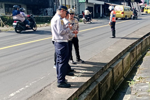 Polisi memeriksa saluran drainase di Jalan Raya Puncak, Cipanas, Senin (30/3/2026). Foto: Dok. kumparan