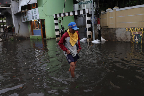 Warga berjalan melintasi genangan di Jalan Pondok Karya, Kelurahan Pela Mampang, Kecamatan Mampang Prapatan, Jakarta Selatan, pada Senin (30/3/2026). Foto: Jamal Ramadhan/kumparan