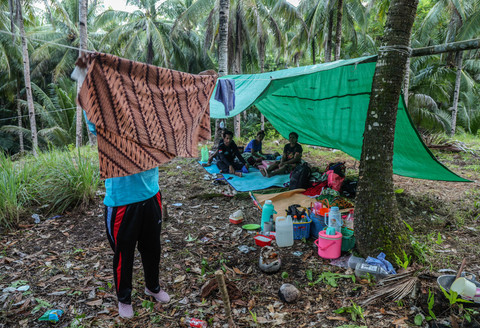 Seorang warga terdampak gempa bumi menjemur sarung di depan tenda yang mereka dirikan di dataran tinggi Kelurahan Mayau, Kecamatan Pulau Batang Dua, Ternate, Maluku Utara, Jumat (3/4/2026). Foto: Andri Saputra/ANTARA FOTO