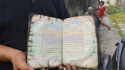 Fisik Al-Qur'an dalam kondisi utuh yang tersisa dari puing-puing kebakaran di Medan, Jumat (3/4/2025). Foto: Amar Marpaung/kumparan