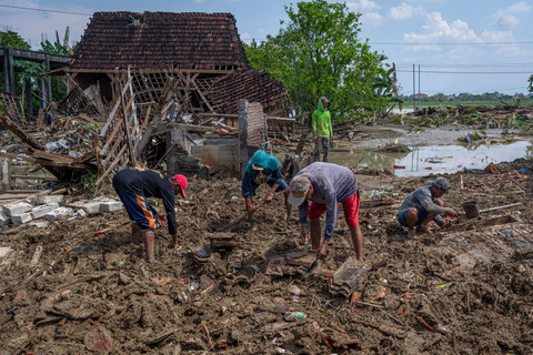 Warga bergotong royong menyingkirkan material tanah yang menimbun sebuah rumah pascabanjir bandang akibat jebolnya tanggul Sungai Tuntang di Dukuh Solondoko, Desa Trimulyo, Kecamatan Guntur, Demak, Jawa Tengah, Minggu (5//4/2026). Foto: Aji Styawan/ANTARA FOTO