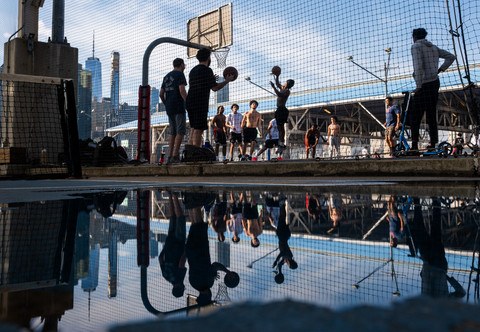 Remaja bermain bola basket di sore hari di Brooklyn Bridge Park, New York, AS, Selasa (14/4/2026). Foto: SPENCER PLATT/Getty Images Via AFP