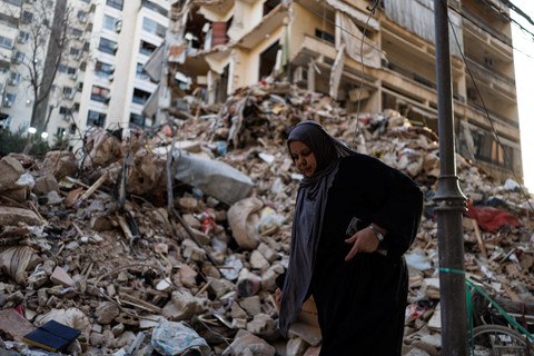 Seorang wanita berjalan melewati bangunan yang rusak di lokasi serangan Israel yang dilakukan pada 8 April, di Corniche al-Mazraa di Beirut, Lebanon, (13/4/2026). Foto: Zohra Bensemra/REUTERS