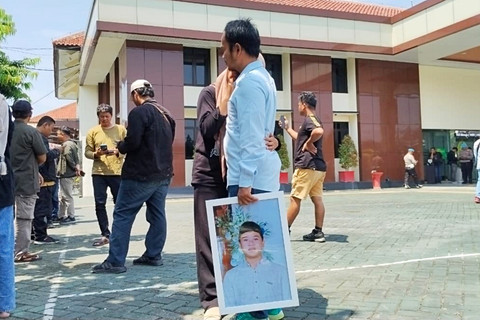 Keluarga korban tongtek maut menangis di pelukan kerabatnya yang sedang membawa foto korban usai sidang pembacaan vonis di PN Pati, Senin (20/4/2026). Foto: Dok. kumparan