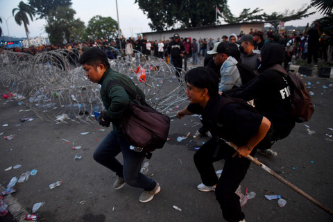 Pengunjuk rasa menarik kawat berduri saat unjuk rasa yang berakhir ricuh di depan kantor Gubernur Kalimantan Timur, Samarinda, Kalimantan Timur, Selasa (21/4/2026).  Foto: Angga Palguna/ ANTARA FOTO