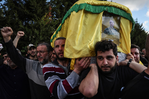 Para pelayat membawa peti mati selama prosesi pemakaman massal untuk para pejuang Hizbullah yang tewas sebelum gencatan senjata 10 hari disepakati antara kelompok militan yang didukung Iran dan Israel, di desa Kfar Sir selatan pada 21 April 2026. Foto: Anwar Amro / AFP