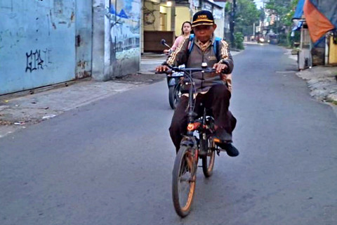 Abdul Aziz, guru yang tengah membonceng anaknya ke Sekolah MI Nurul Islam 1. Foto: Rayyan/Kumparan