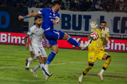 Pesepak bola Persib Bandung Julio Cesar (tengah) menendang bola saat berupaya dihalau penjaga gawang Arema FC Lucas Frigeri dalam pertandingan BRI Super League di Stadion Gelora Bandung Lautan Api (GBLA), Bandung, Jawa Barat, Jumat (24/04/2026). Foto: Abdan Syakura/ANTARA FOTO