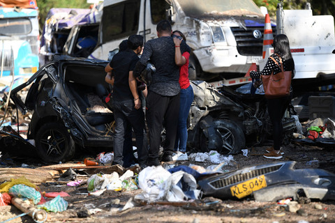 Kerabat korban bereaksi di samping kendaraan yang hancur setelah serangan dengan bahan peledak yang menewaskan lebih dari selusin orang di Jalan Raya Pan-Amerika di daerah El Tunel, Cajibio, Kolombia, 26 April 2026. Foto: REUTERS/Jair Coll