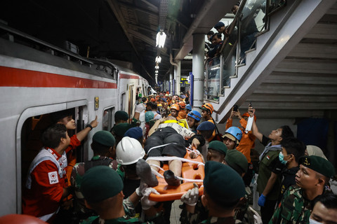 Petugas mengevakuasi penumpang KRL Commuterline yang ditabrak KA Argo Bromo Anggrek di Stasiun Bekasi Timur. Foto: Dhemas Reviyanto/ANTARA