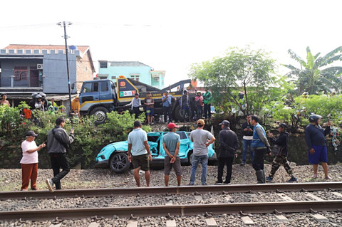 Warga mengamati kondisi taksi listrik yang rusak usai mengalami kecelakaan dengan KRL Commuter Line di Bekasi Timur, Bekasi, Jawa Barat, Selasa (28/4/2026). Foto: Iqbal Firdaus/kumparan