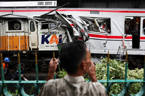 Seorang pria memandangi puing-puing di lokasi kejadian pascatabrakan maut yang melibatkan kereta komuter (Commuter Line) dan kereta api jarak jauh di Bekasi, pinggiran Jakarta, Selasa (28/04/2026). Foto: Willy Kurniawan/REUTERS